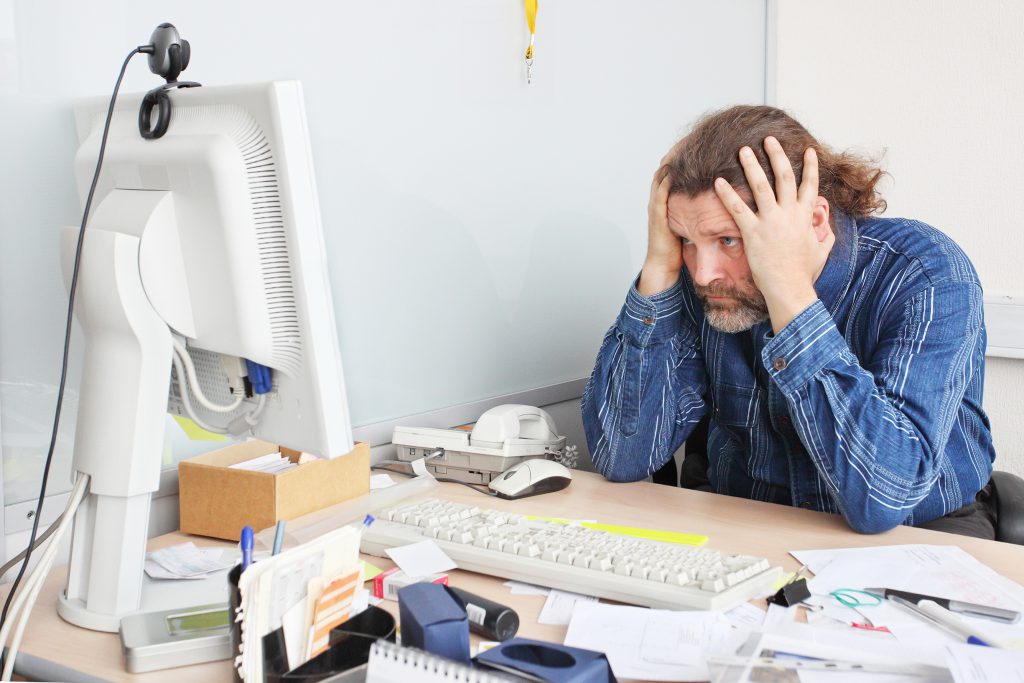 man looking at computer very stressed